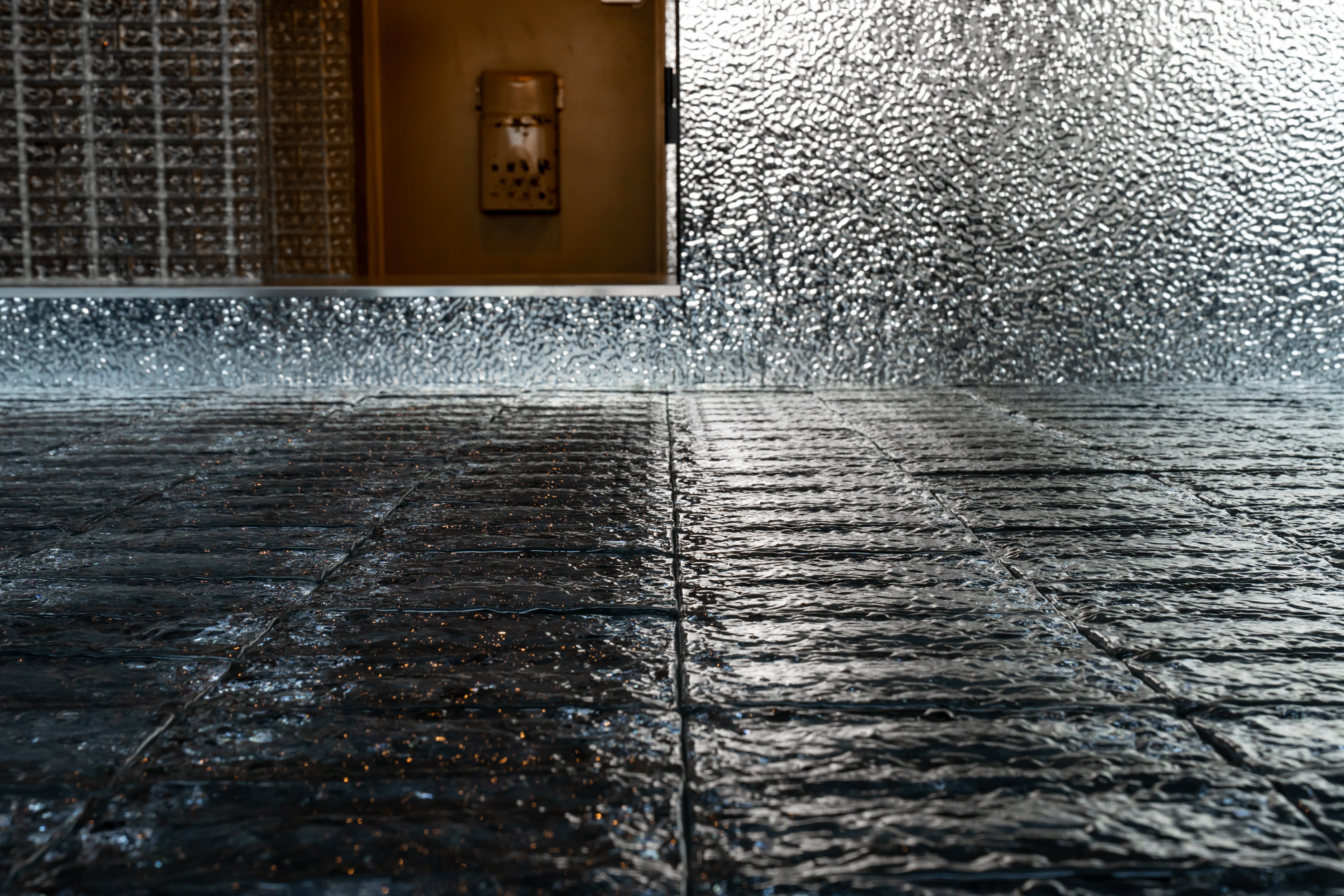 床仕上げにTHE GLASSを使用した施工事例。閉鎖的な空間に透明感と反射を加えた内装デザイン。