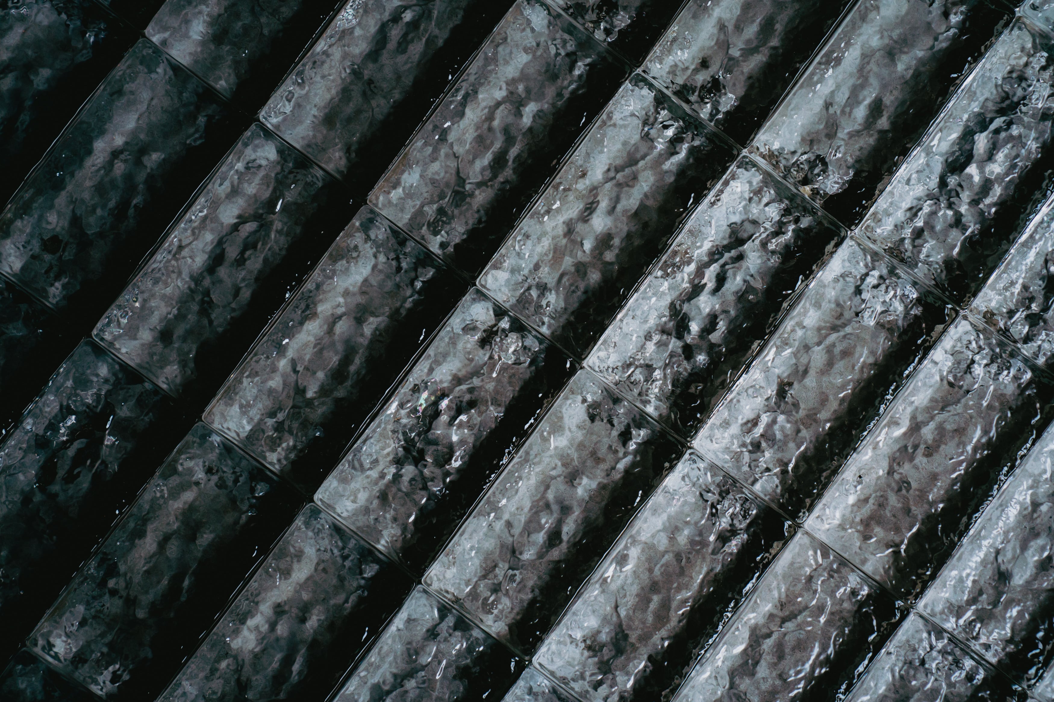 THE GLASSの床が静かに光を映すミニマルな空間。無機質な壁と床素材が緊張感のある雰囲気を演出。