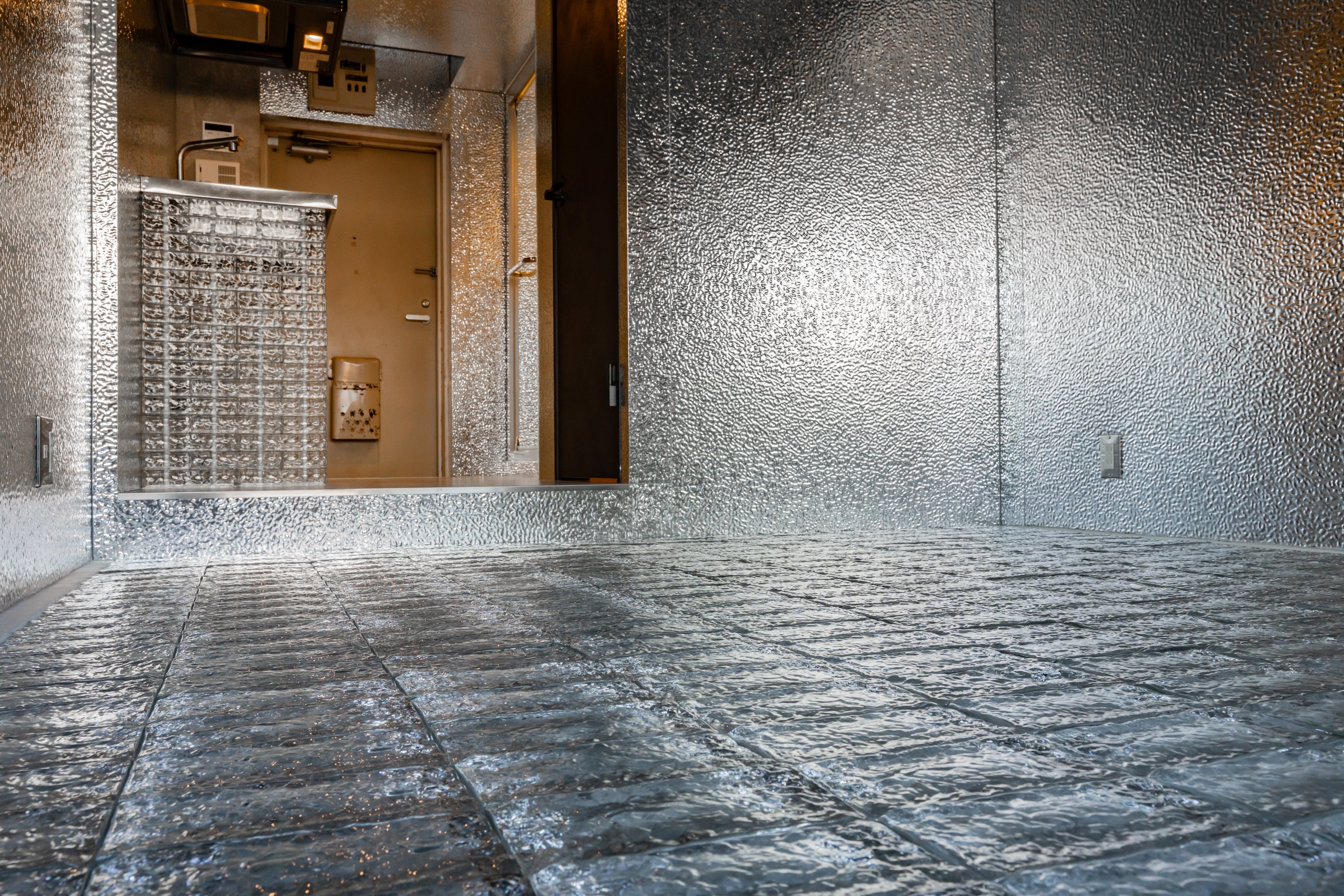 THE GLASSを床材に採用した内装事例。ガラス特有の反射と質感が空間の奥行きを強調している。