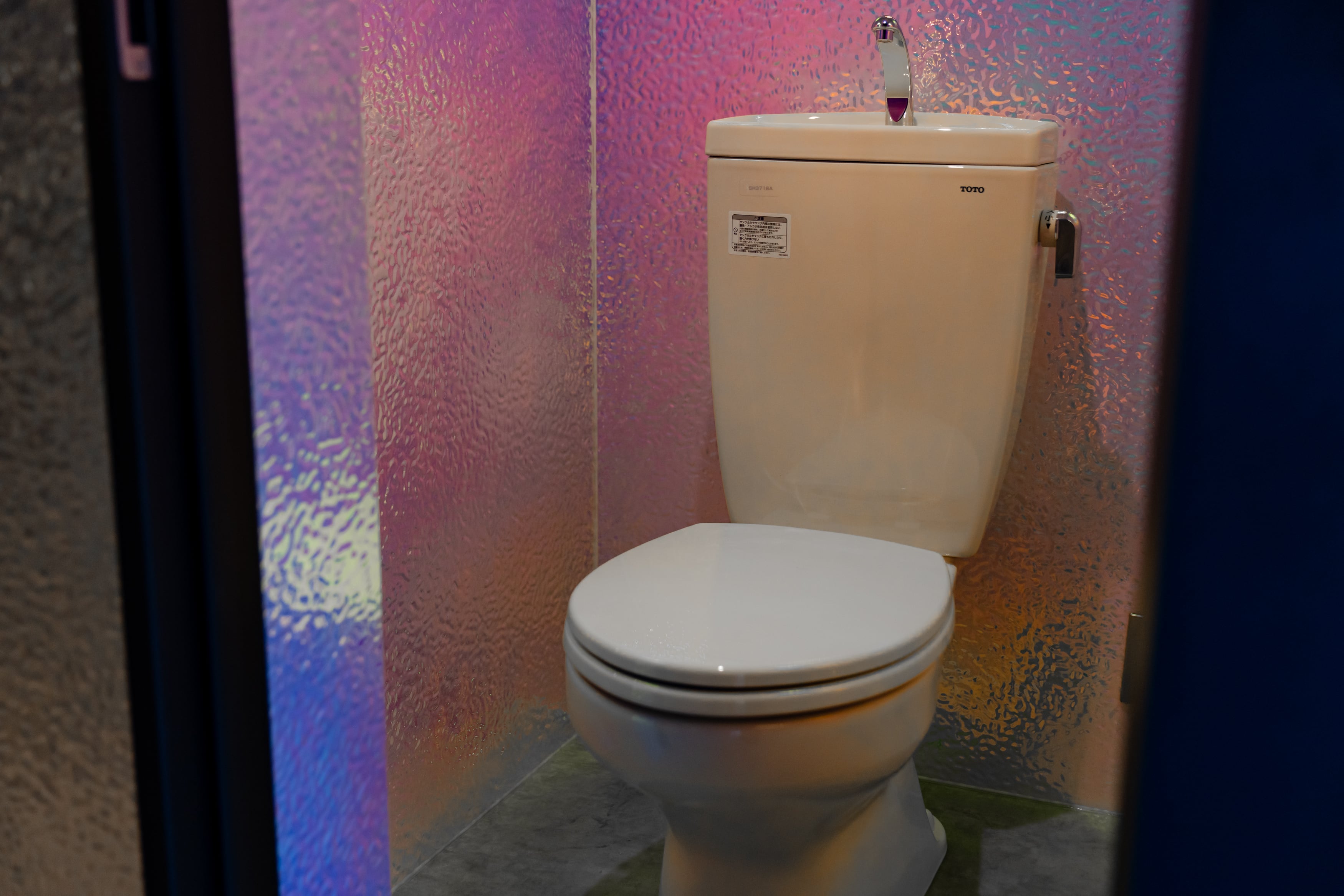 トイレの壁面にTHE PANELを採用した内装。光の反射で表情が変わるパネルデザイン。