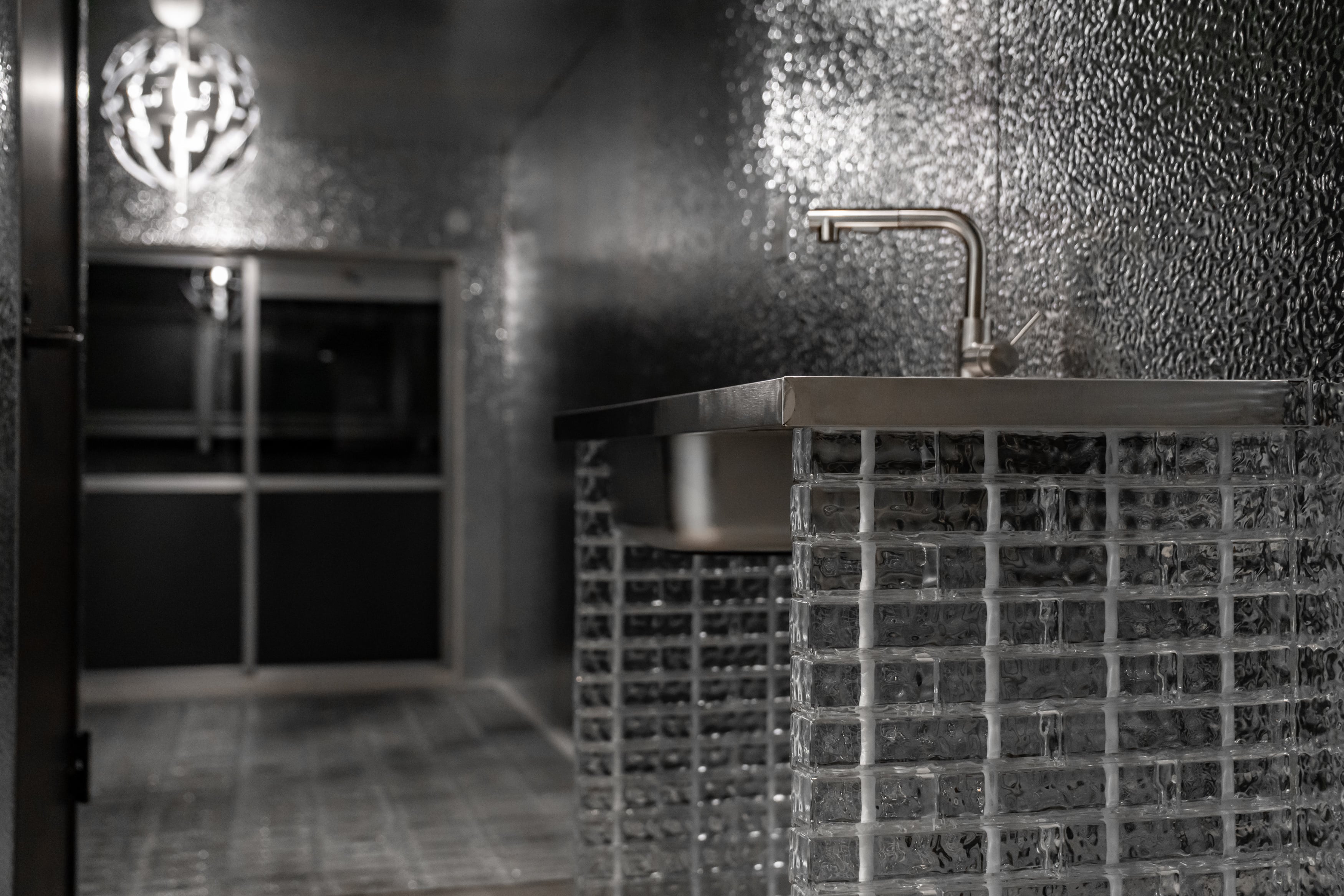 THE GLASSを使用したキッチンの内装事例。ガラスブロックのカウンターが印象的なデザイン。