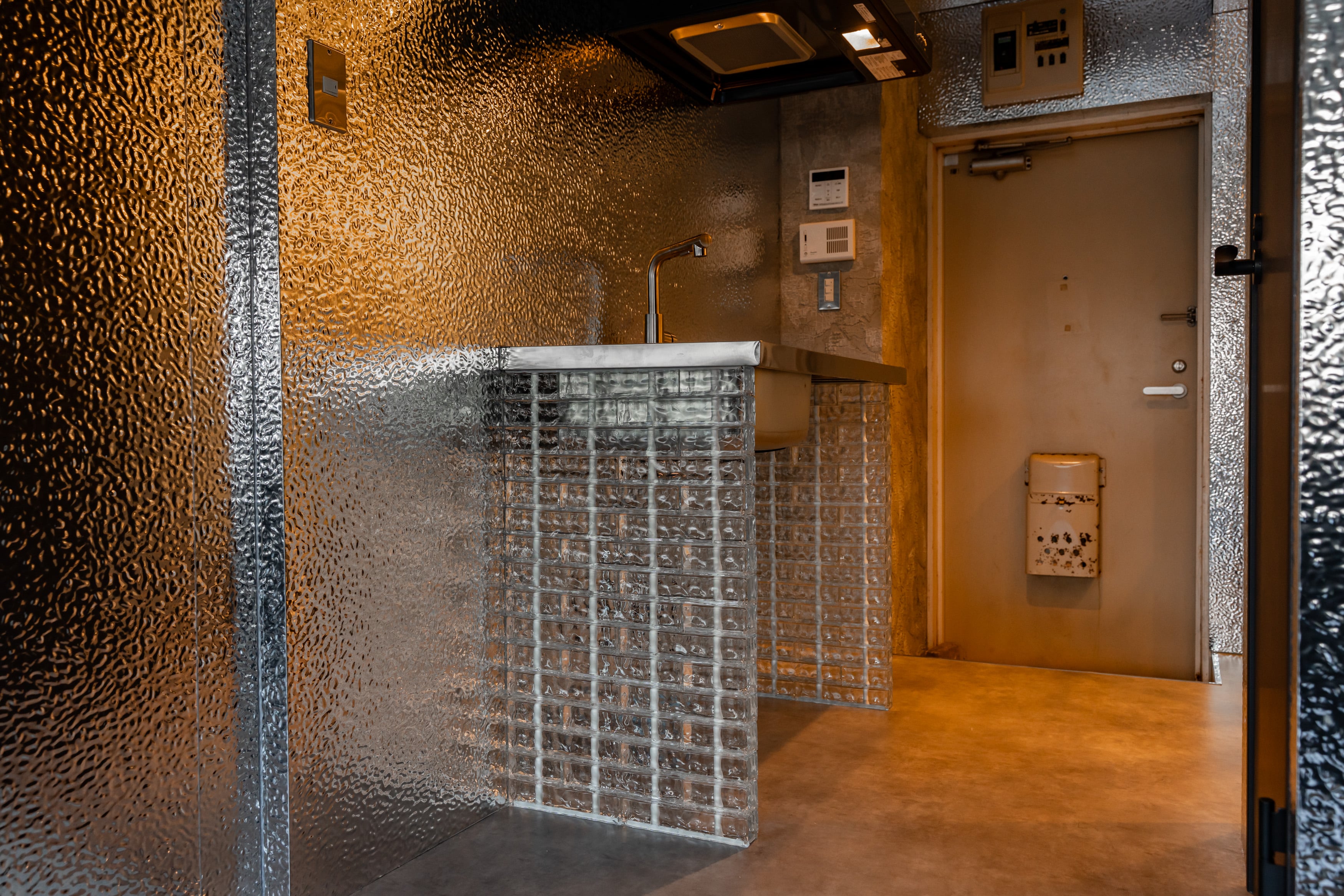 THE GLASSを用いたキッチンの施工事例。カウンターにガラス素材を取り入れた内装デザイン。