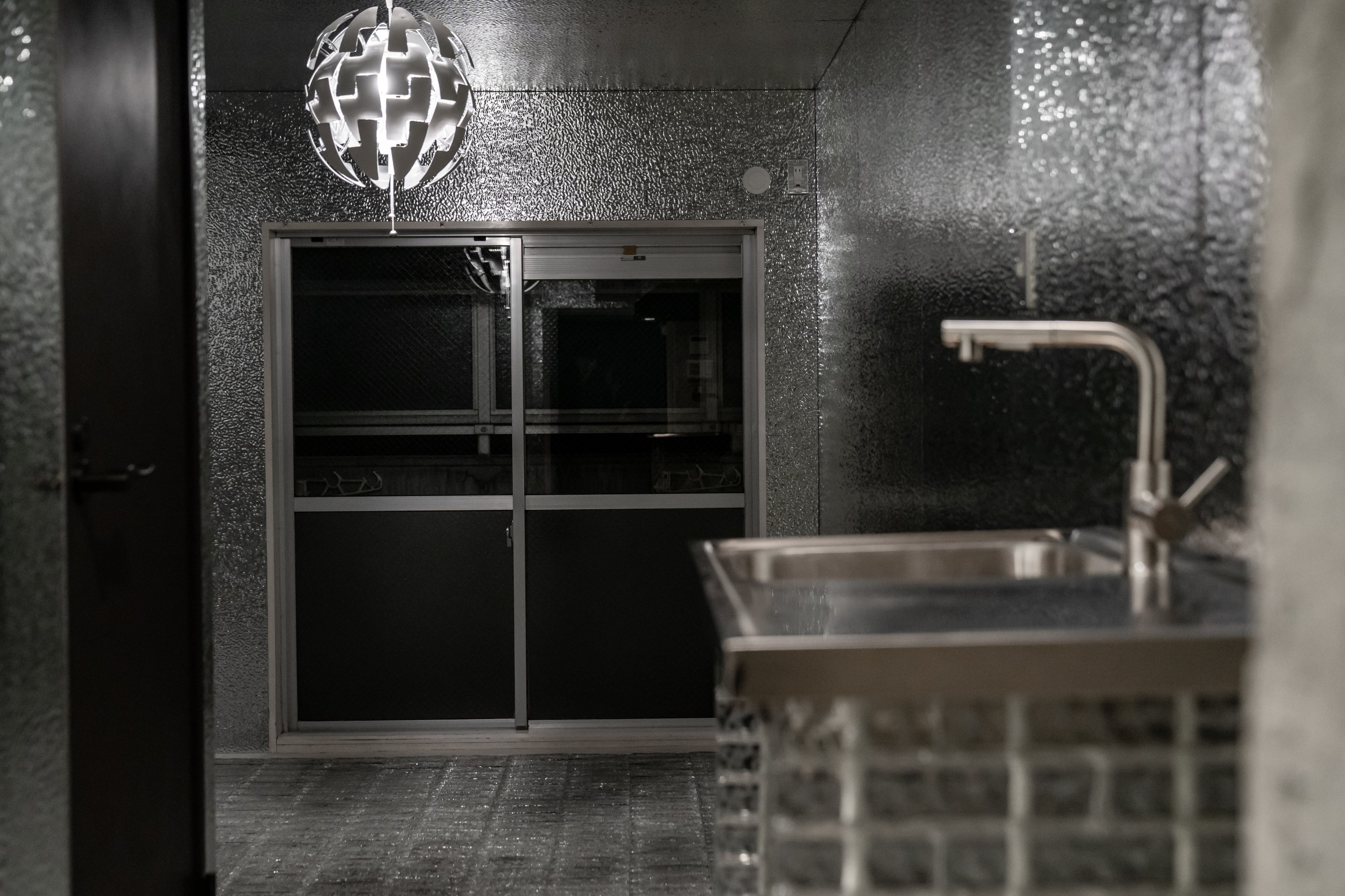 夜の照明下で表情を変えるTHE GLASSと、壁・天井にTHE PANELを使用した内装空間