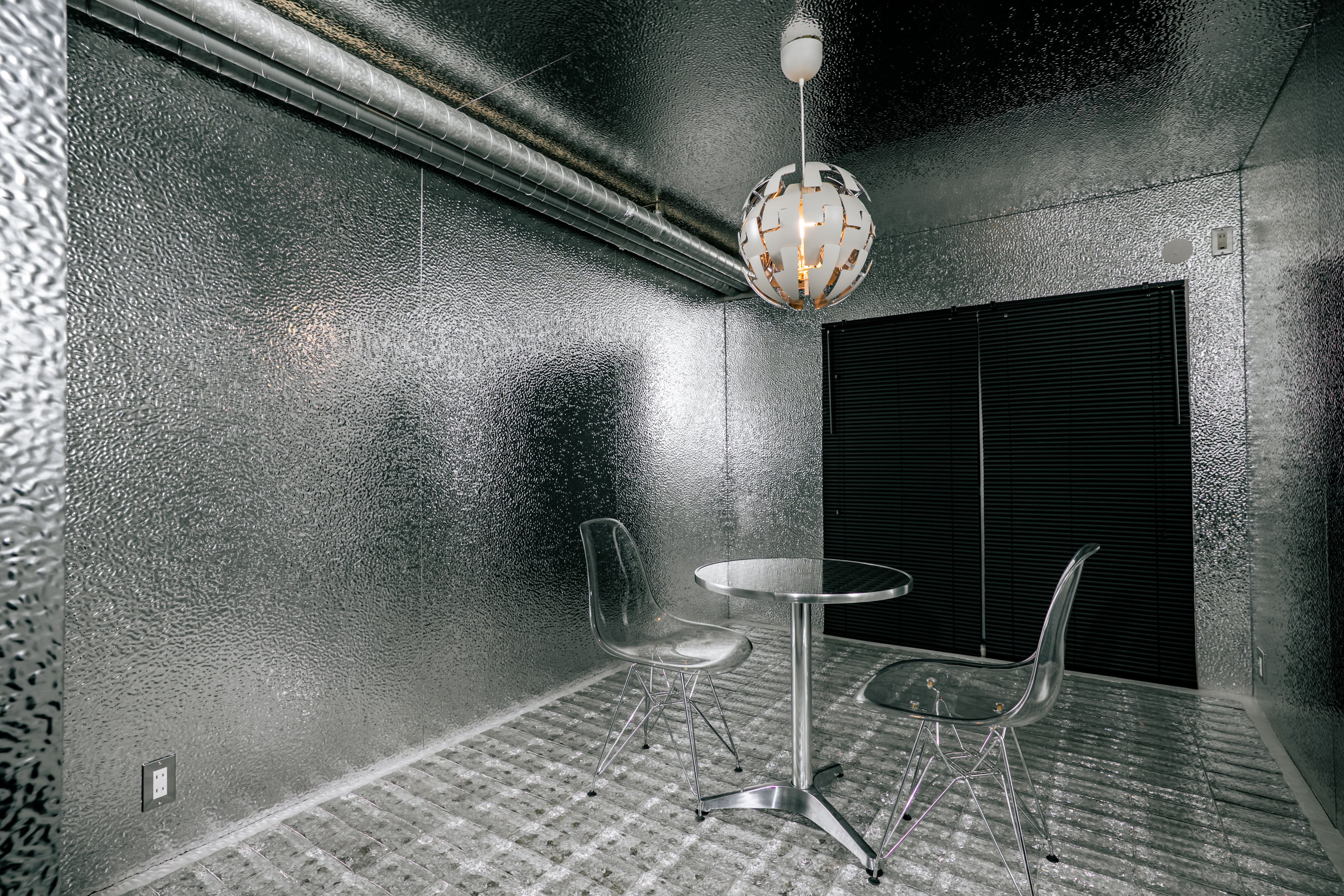 夜の照明下で表情を変えるTHE GLASSと、壁・天井にTHE PANELを使用した内装空間