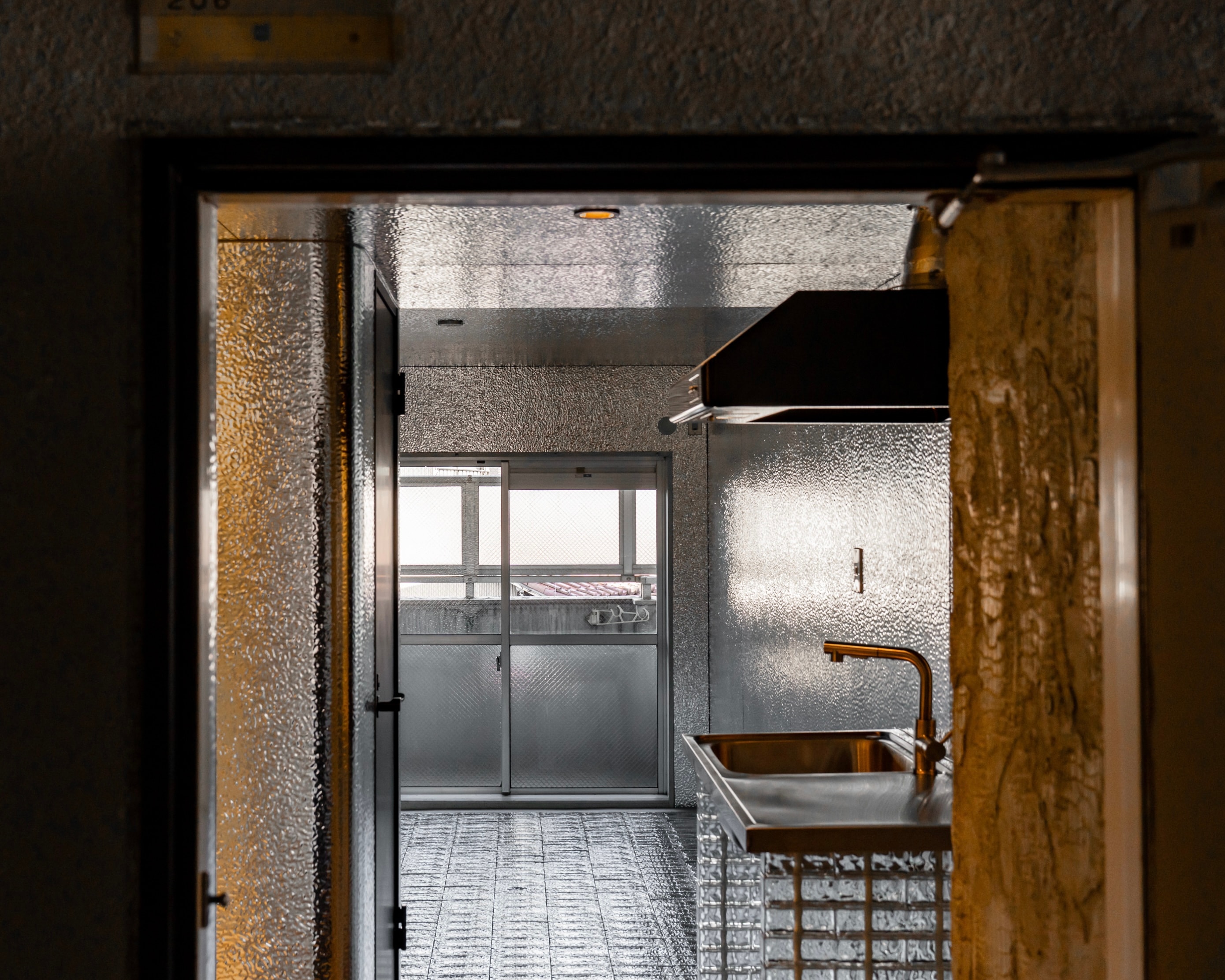 名古屋市西区の1Rマンションモデルルーム室内|THE PANELの壁とTHE GLASS床、キッチン・バルコニーまで見通せるデザインリノベーション事例