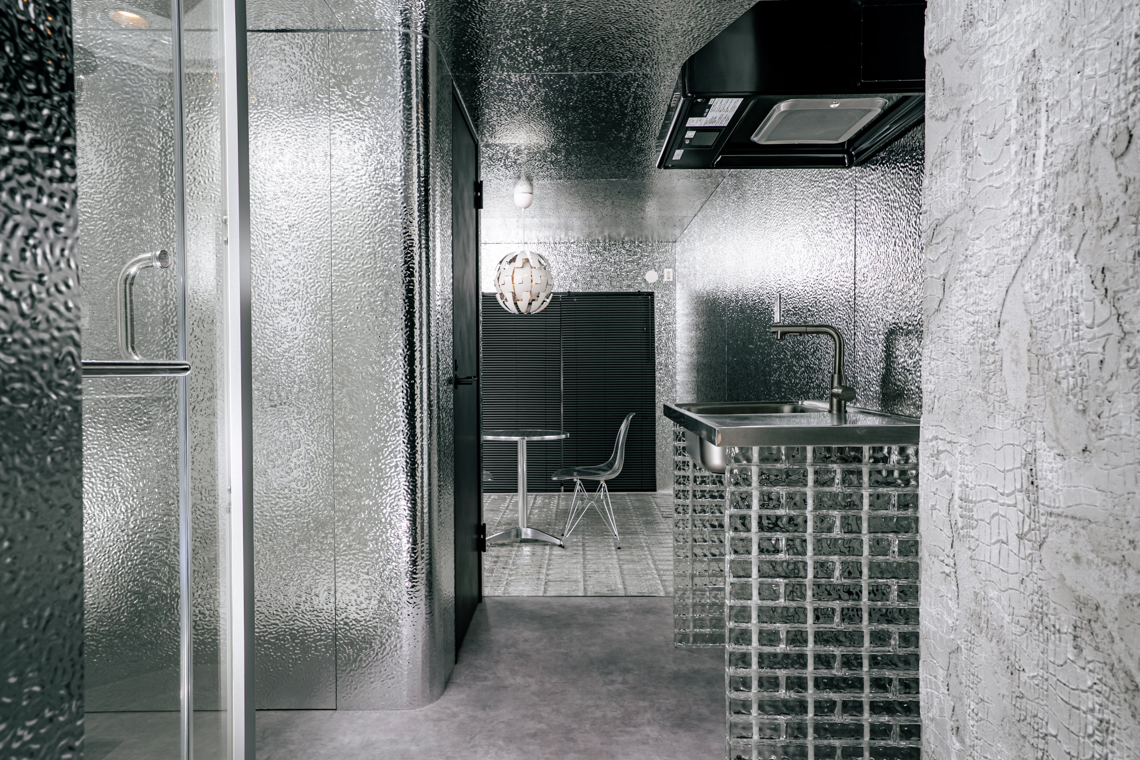 名古屋市西区の1Rマンションモデルルーム室内|THE PANELの壁とTHE GLASS床、キッチン・バルコニーまで見通せるデザインリノベーション事例