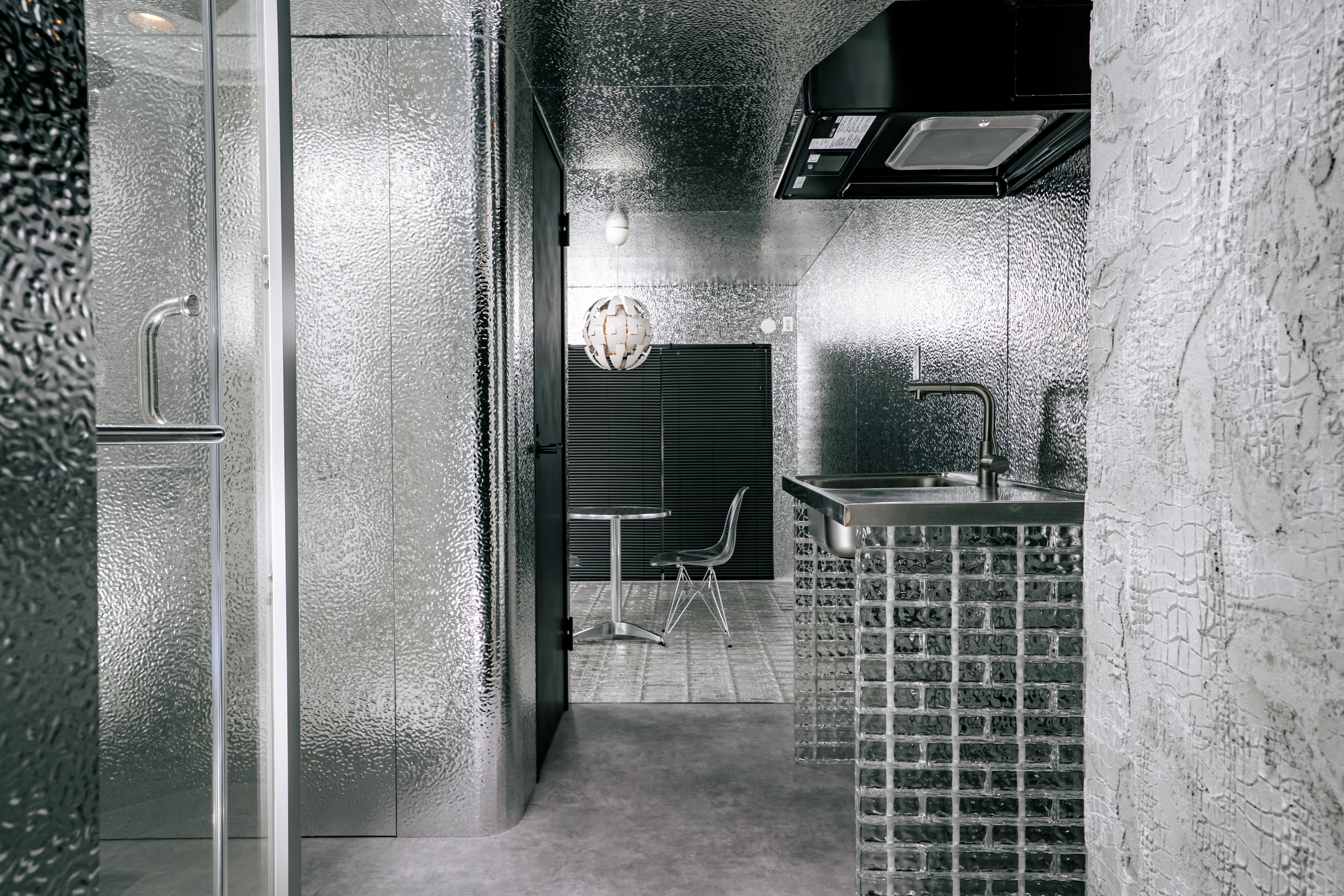 名古屋市西区の1Rマンションモデルルーム室内|THE PANELの壁とTHE GLASS床、キッチン・バルコニーまで見通せるデザインリノベーション事例