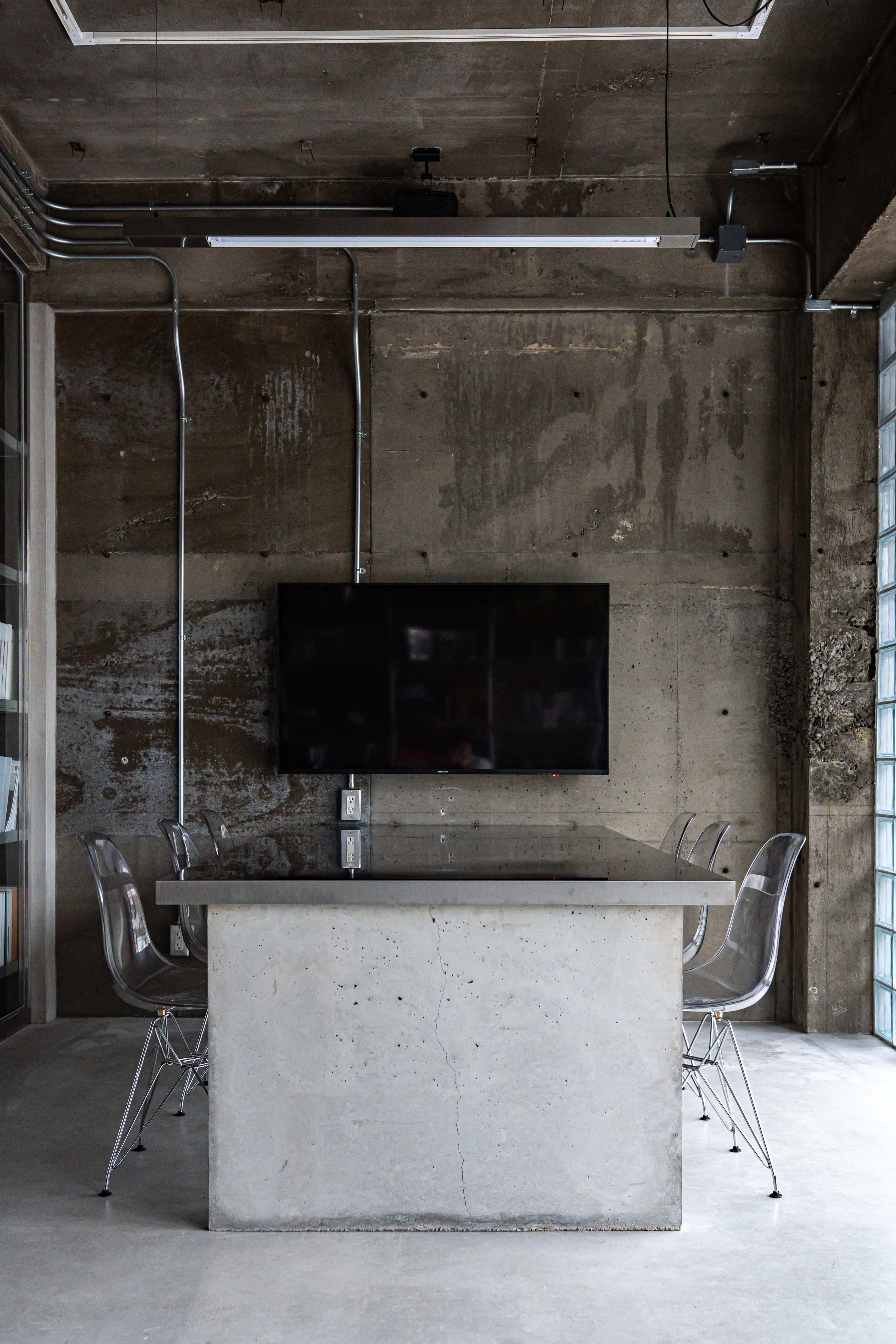 インダストリアルデザインの会議室内装|コンクリート天板テーブルと壁掛けモニター(名古屋)