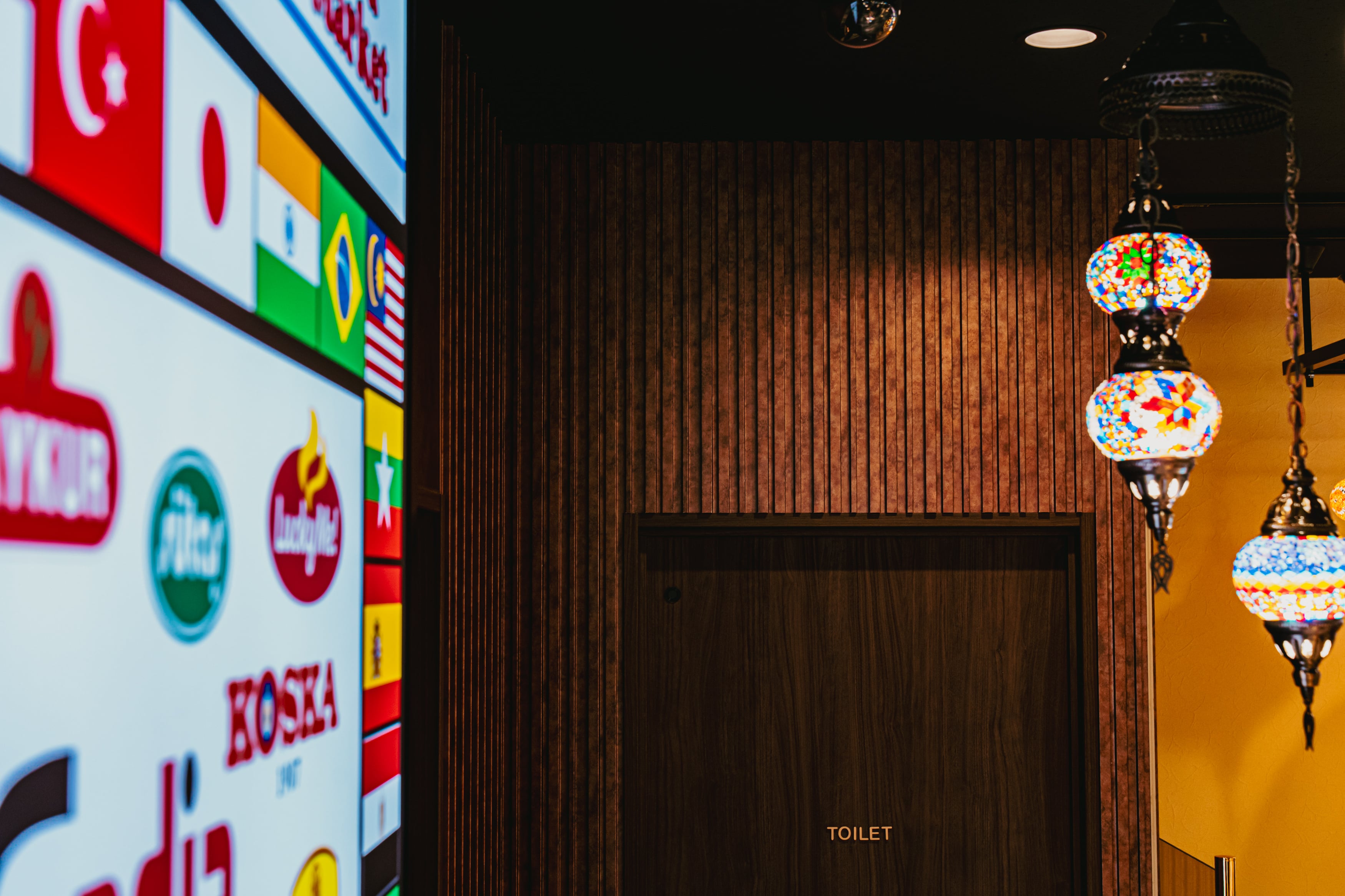 THE PANEL アクセントウォール|飲食店内装の縦張り木目パネルとモザイクランプのコーディネート事例